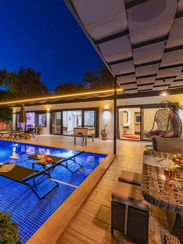 Villa met verlicht zwembad in de avond