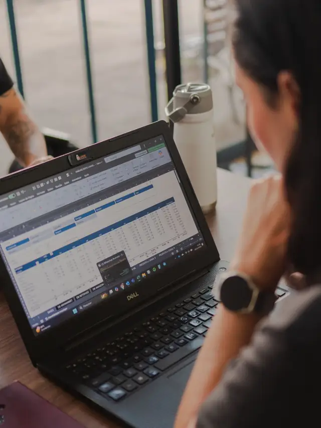 Vrouw bekijkt een tabel met cijfers op haar laptop
