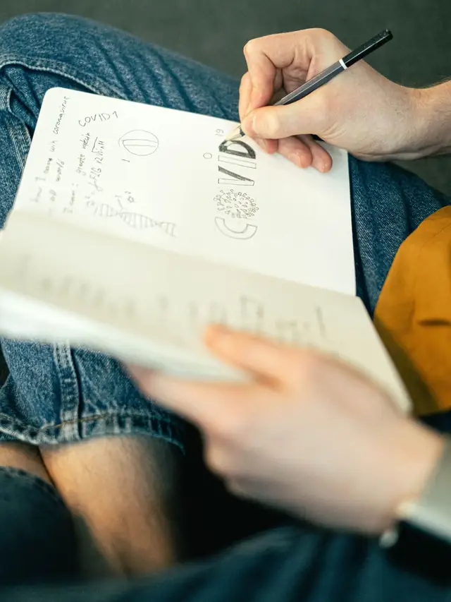 Iemand maakt aantekeningen in een notitieboek